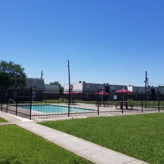 the pool is fenced off with a wrought iron fence