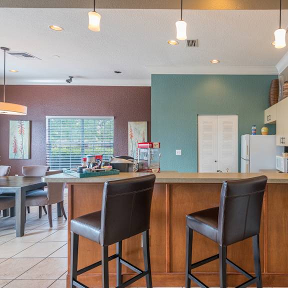 a kitchen with a bar area and two chairs.