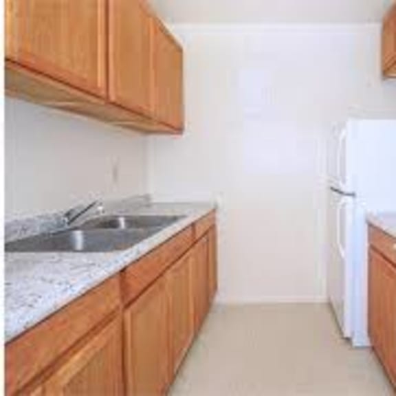 a kitchen with white appliances and wooden cabinets