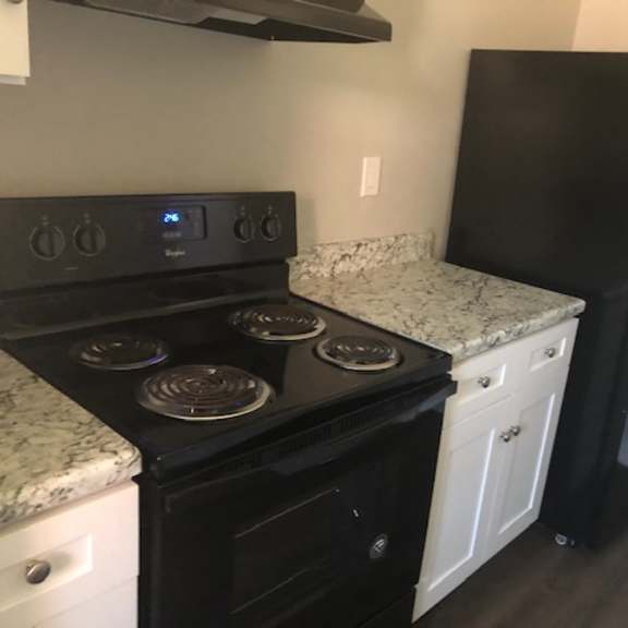 a kitchen with a black stove and a black refrigerator