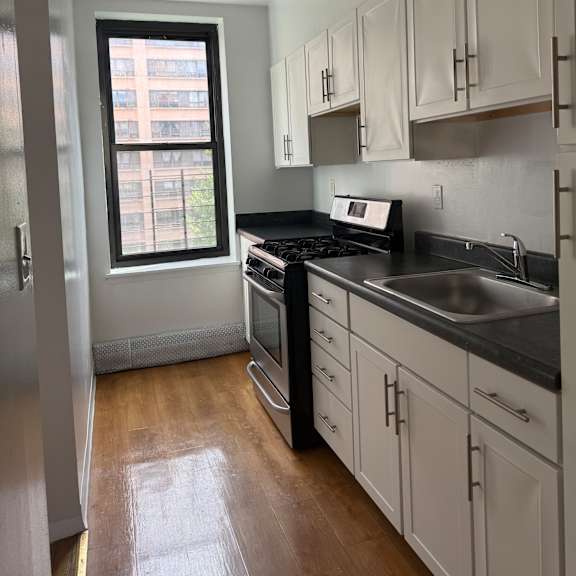 a kitchen with a window and a stainless steel counter.