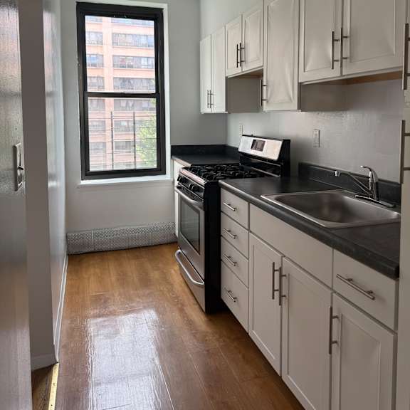 a kitchen with a window and a stainless steel counter.