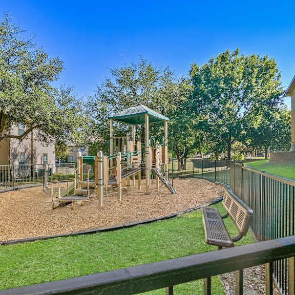 a playground with a swing set and a green gazebo.