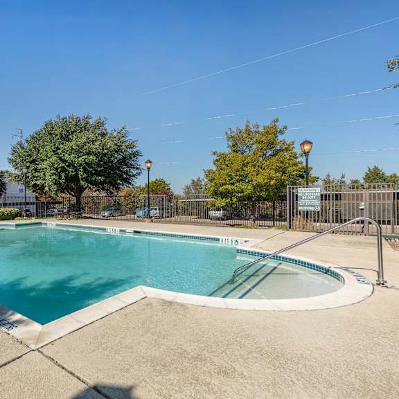 a large outdoor swimming pool surrounded by a fence.