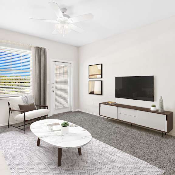 a living room with a white couch, a coffee table, a television, and a plant.