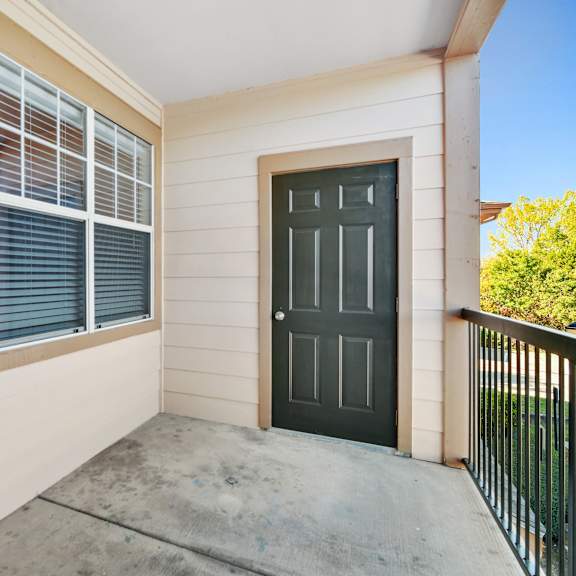 a black door is on the right side of a white wall.