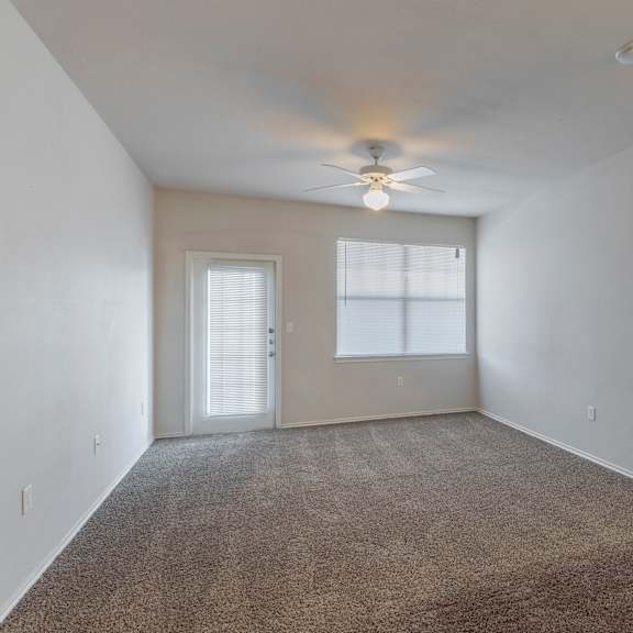 a room with a carpeted floor and a ceiling fan.