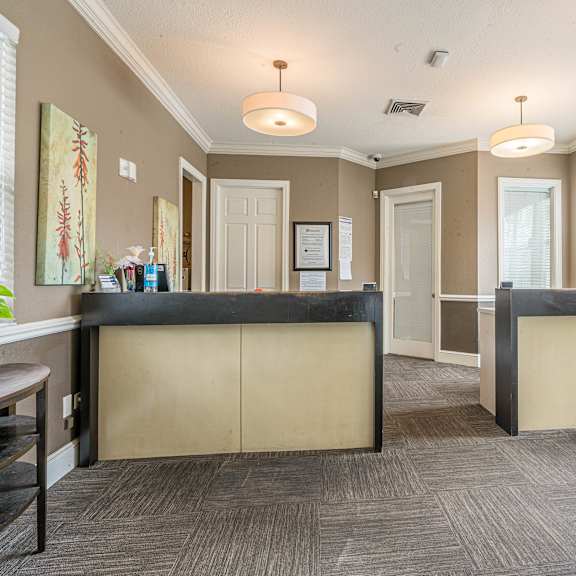 a reception area with a black counter and beige walls.