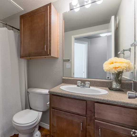 a white shower curtain hangs over a white bathtub in a bathroom.