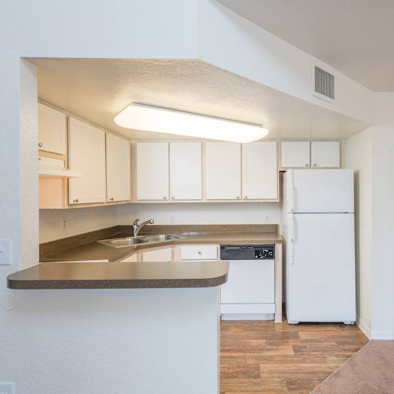 a kitchen with white cabinets and a white refrigerator.