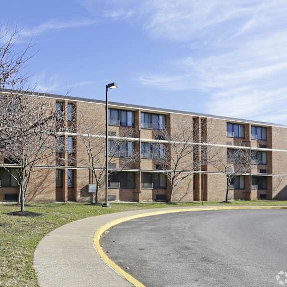 a large building with a parking lot in front.