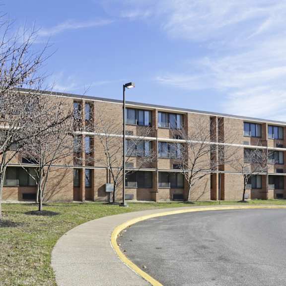 a large building with a parking lot in front.