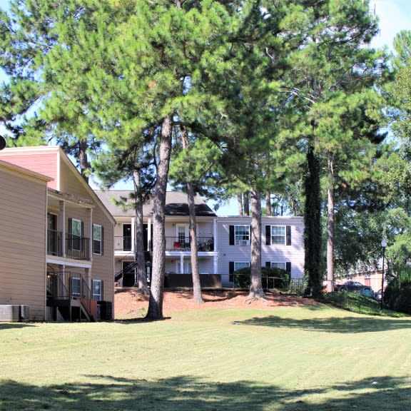 a row of houses with trees in front of them at clarkston station apartments, clarkston