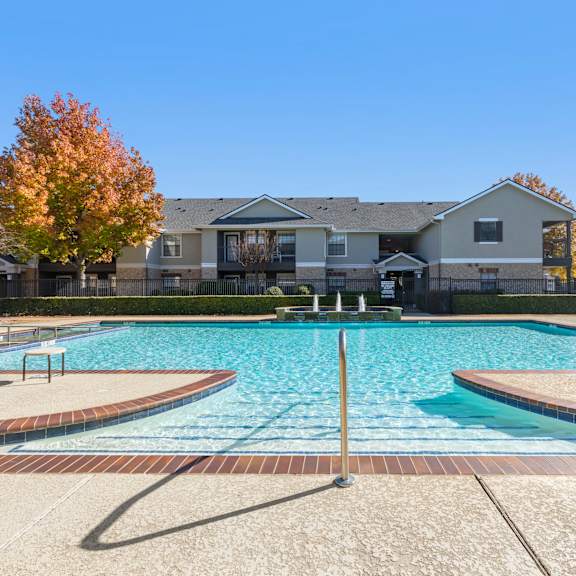 a swimming pool in front of a residential building.