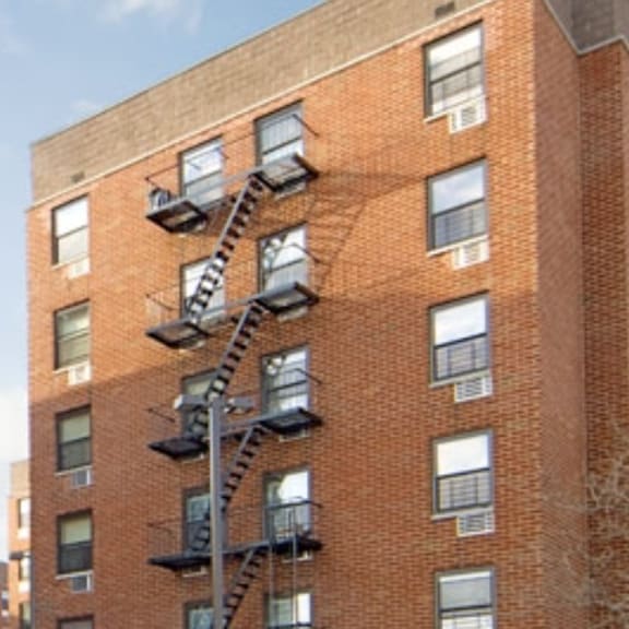 two tall brick apartment buildings with fire escapes on the side of them