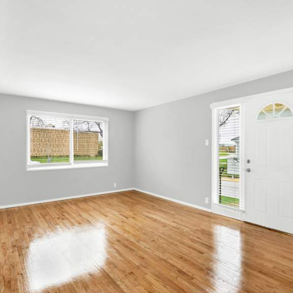 a bedroom with hardwood floors and grey walls