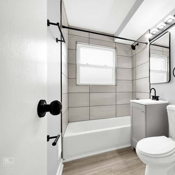 a bathroom with gray walls and white fixtures