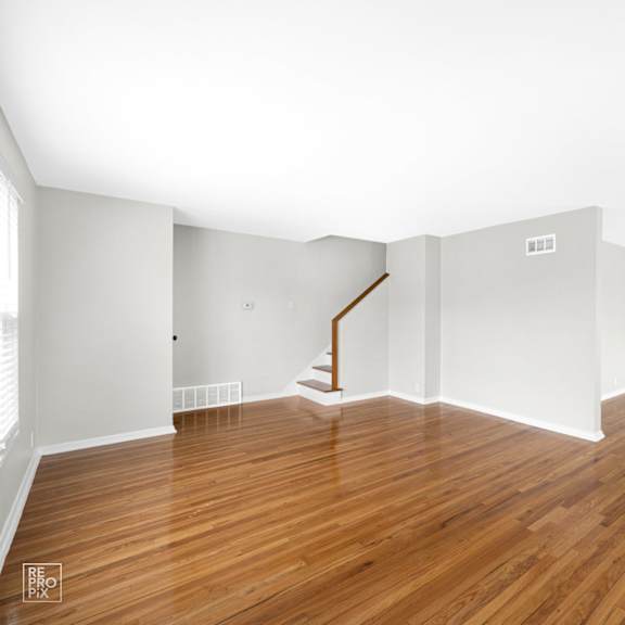 a bedroom with hardwood floors and grey walls