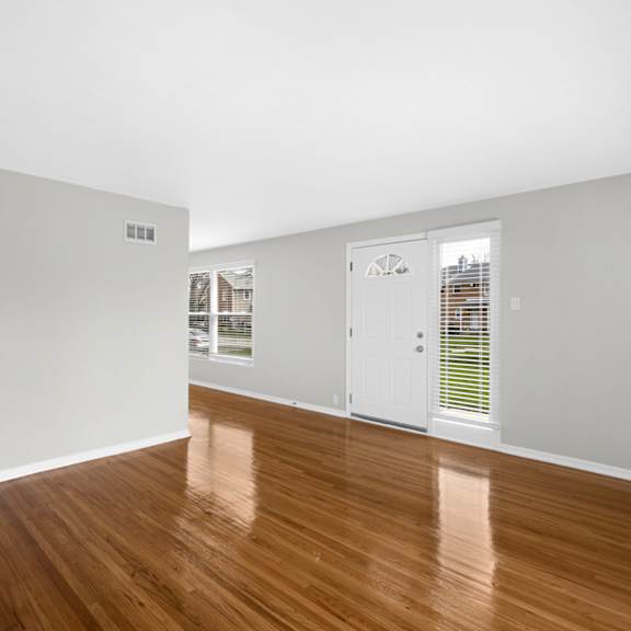 a bedroom with hardwood floors and grey walls