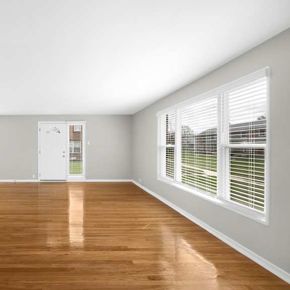 a bedroom with hardwood floors and grey walls