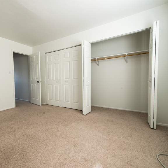 an empty room with a closet and a door
