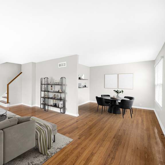 a living room with a gray couch and a dining room table