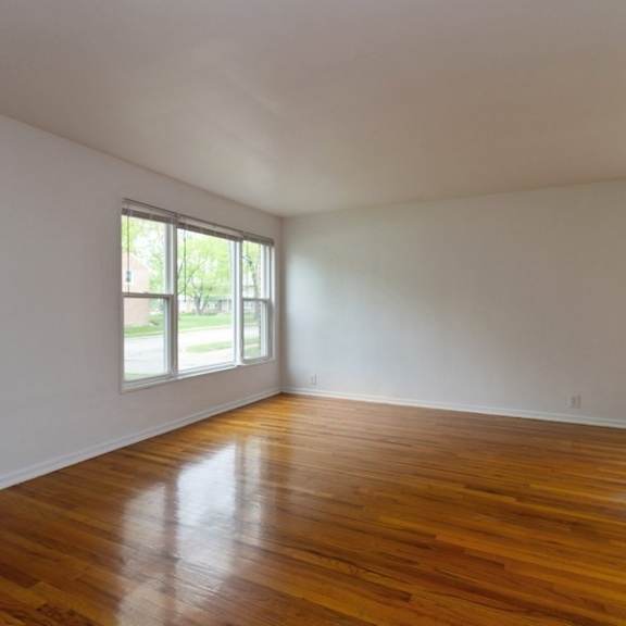 an empty living room with white walls and wood floors