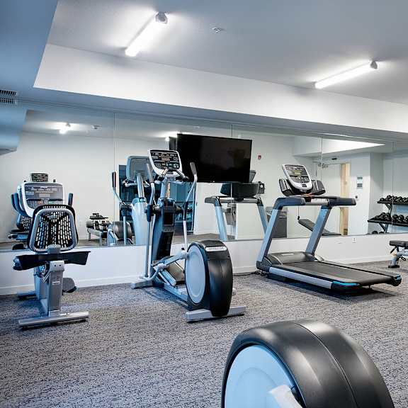 a large fitness room with treadmills and other exercise equipment at eastgate apartments, rochester, minnesota