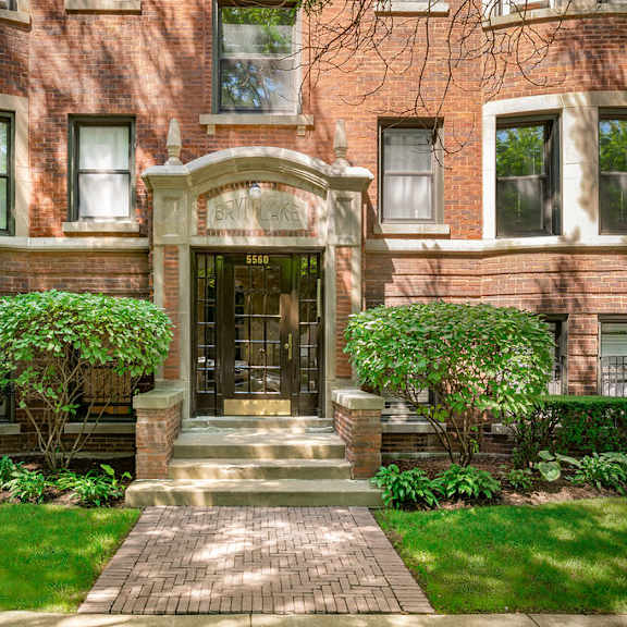 a red brick building with a green lawn in front.