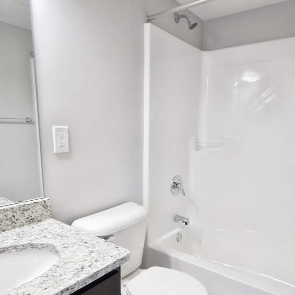 white bathroom with tub and marble counter at integrity medina apartments,  ohio