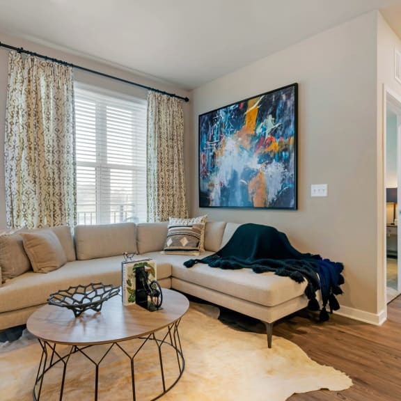 an open concept living room and dining area with a white dining table and rattan chairs at JTB Apartments, Jacksonville, FL, 32256