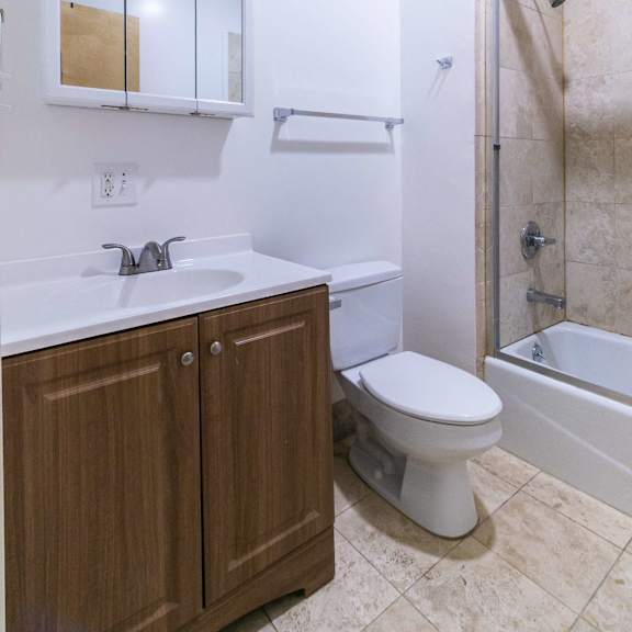 a white sink with a wooden cabinet below it.