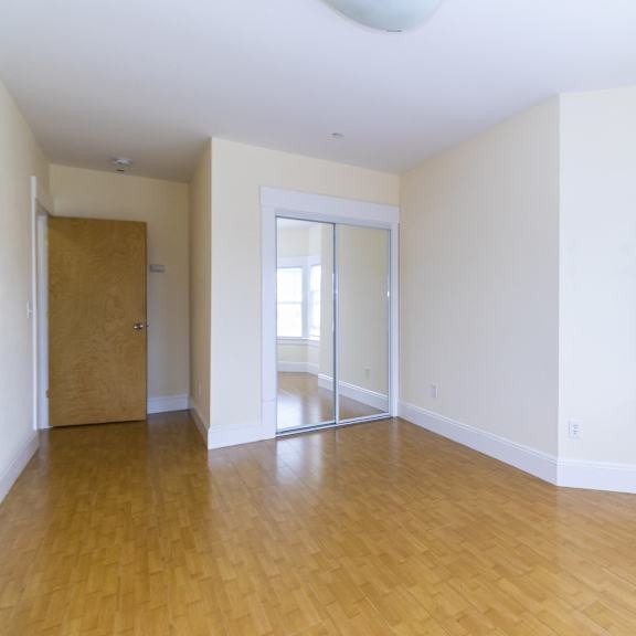 a room with wooden floors and white walls.