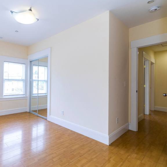 a room with a closet and windows.