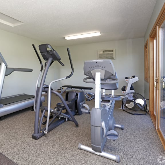 fitness room with treadmill, elliptical and bike