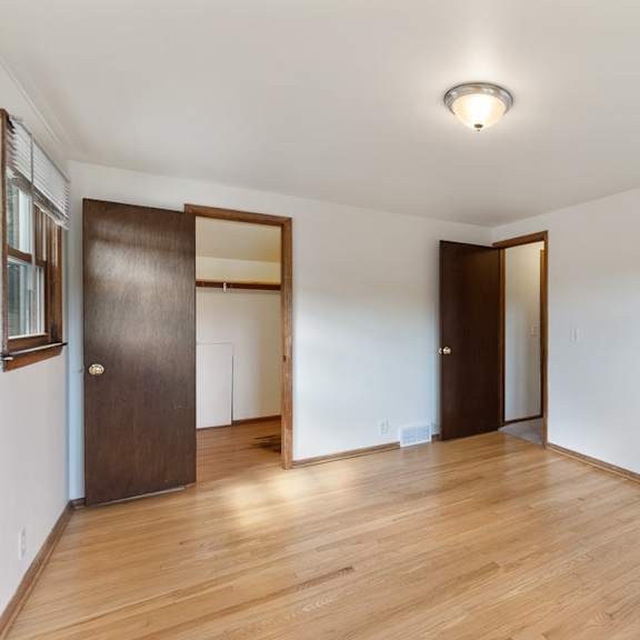 a living room with hardwood floors and white walls