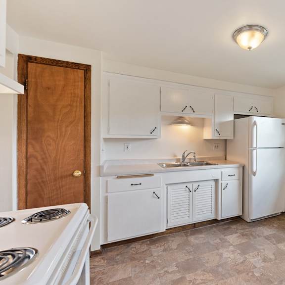 a kitchen with white cabinets and a white refrigerator