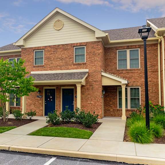 an exterior view of our exton apartments at severgn with well-maintained lawns and landscaping near resident parking spaces in front of the buildings.
