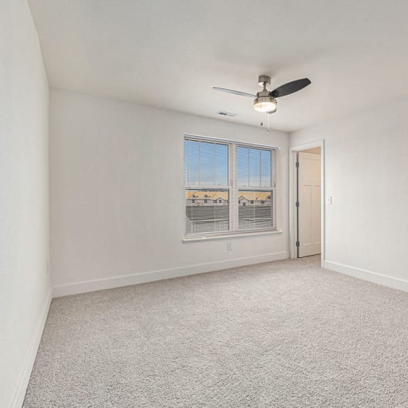 Thumbnail 12 of 17 Bedroom with plush carpeting and large window at Eagle Ridge Apartment Homes, Traverse City, 49685