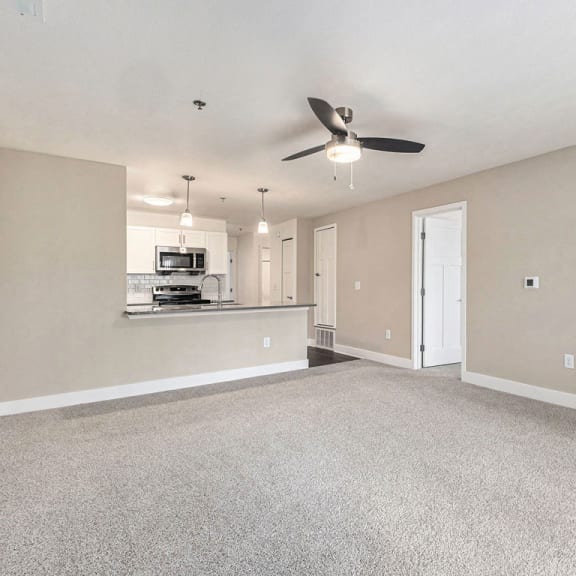Thumbnail 6 of 17 Living room with carpet leading to kitchen at Eagle Ridge Apartment Homes,  Michigan 49685