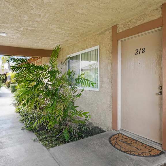 a brown door with a doormat in front of a house.
