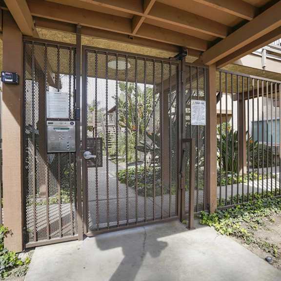 a metal gate with a lock and a keypad entry system.