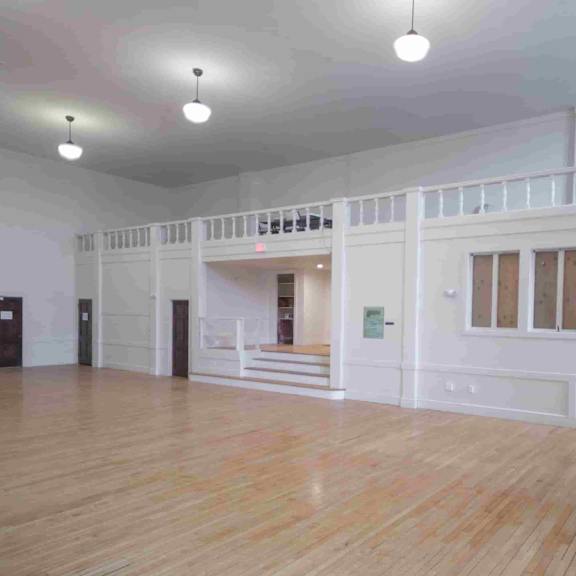 a large empty room with wooden floors and white walls.