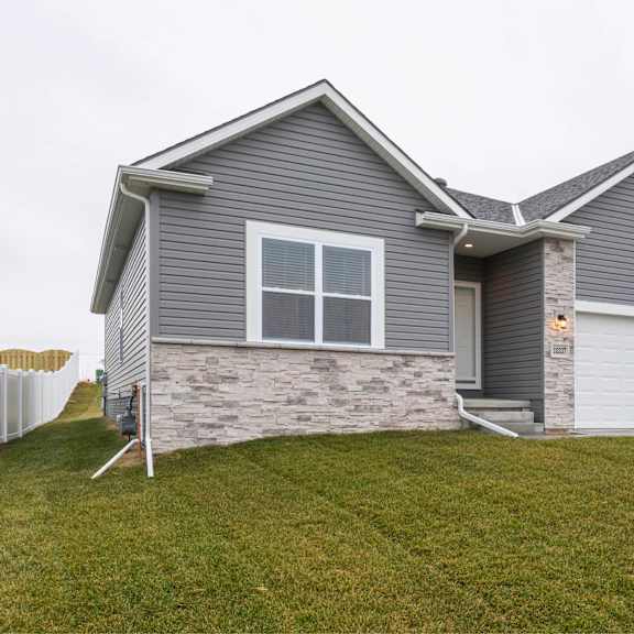 a house with a grey siding and a white garage door.