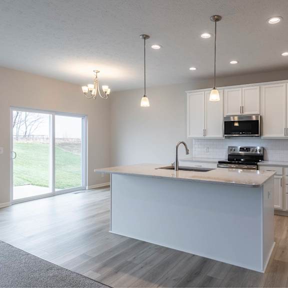 a modern kitchen with a large island and stainless steel appliances.
