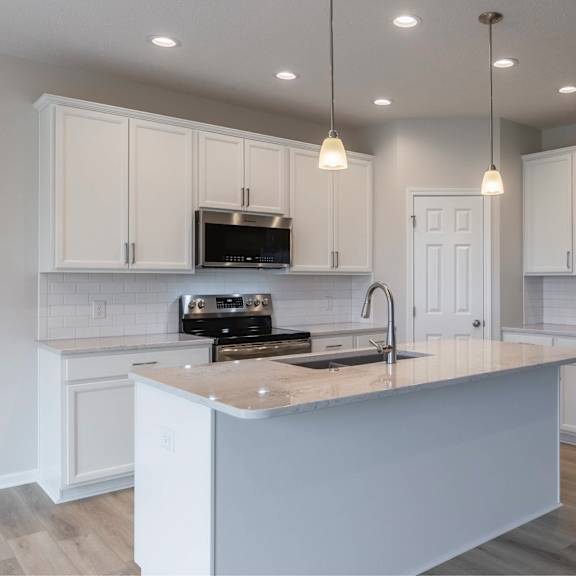 a kitchen with white cabinets and a wooden island.