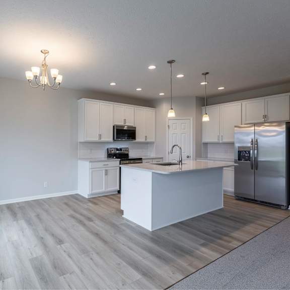 a modern kitchen with a large island and stainless steel appliances.
