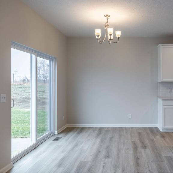 a kitchen with white cabinets and a wooden floor.