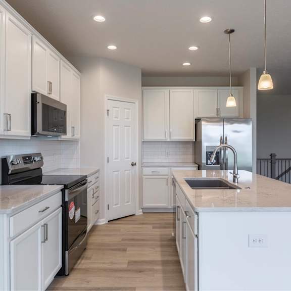 a kitchen with white cabinets and appliances.