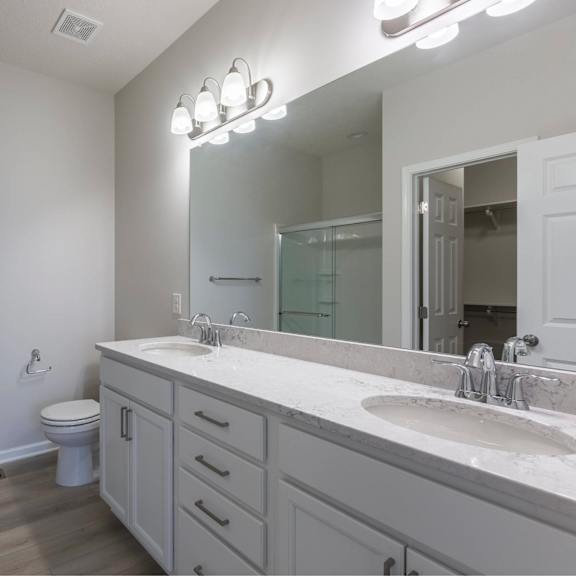 a bathroom with a toilet, sink, and mirror.